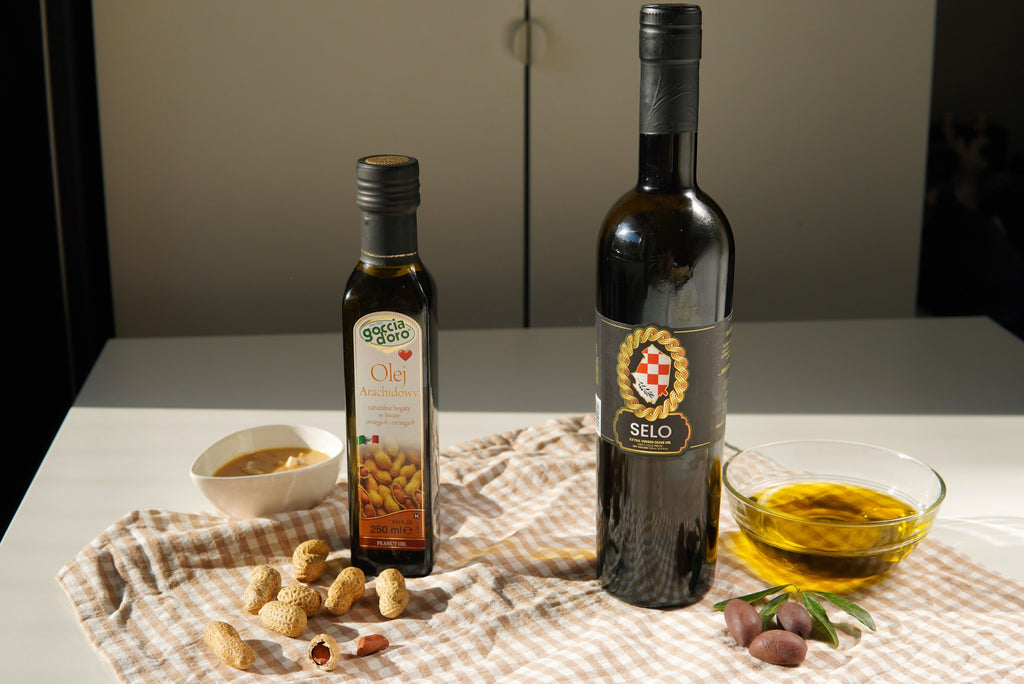 Two oil bottles on a table: one filled with peanut oil and the other showcasing Croatian olive oil.